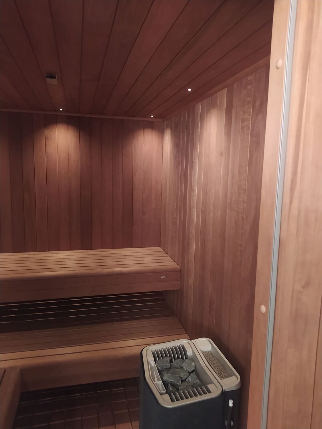 interno sauna scura con faretti e stufa vapore